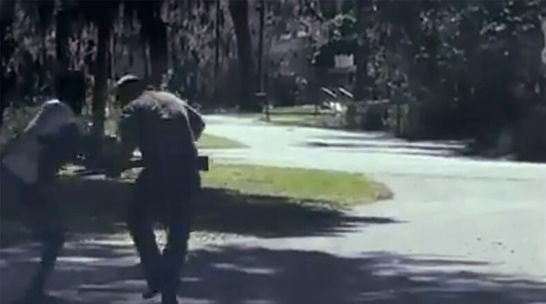 ADDS THAT THE AP HAS NOT BEEN ABLE TO VERIFY THE SOURCE OF THE VIDEO - This image from video posted on Twitter Tuesday, May 5, 2020, purports to show Ahmaud Arbery, left, struggling with Travis McMichael over a shotgun on a street in a neighborhood outside Brunswick, Ga., on Feb. 23, 2020. McMichael's father, Gregory, who was also at the scene, said Arbery was shot as the two men fought over the gun, according to the police report. The AP has not been able to verify the source of the video. (Twitter via AP)