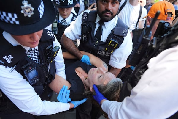 Police officers remove a person after they took part in a protest in Parliament Square, to call for de-proscription of 'Palestine Action' after a ban against the organisation was announced, in London, Saturday July 12, 2025. (James Manning/PA via AP)