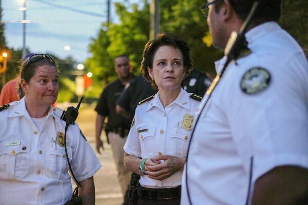 Then-Atlanta Police Chief Erika Shields huddles with officers on Briarcliff Road in Atlanta as protesters marched through Virginia Highlands past curfew on June 5. BEN GRAY FOR THE ATLANTA JOURNAL CONSTITUTION