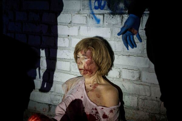 An injured woman sits near her house, which was damaged by a Russian airstrike, in a residential neighbourhood in Kyiv, Ukraine, on Thursday, April 24, 2025. (AP Photo/Evgeniy Maloletka)
