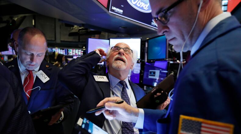 Traders Michael Urkonis, left, and Peter Tuchman, center, work on the floor of the New York Stock Exchange, Monday, Feb. 24, 2020. Stocksfell sharply on Wall Street as coronavirus cases spread beyond China, threatening to disrupt the global economy. (AP Photo/Richard Drew)