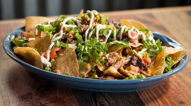 Big Tex Nachos with brisket, queso, lettuce, pico de gallo, black beans, sour cream, and roasted corn. Photo credit- Mia Yakel.