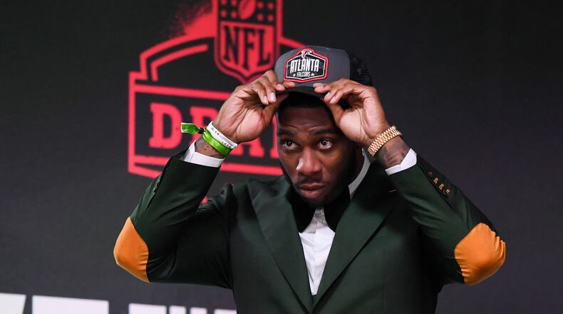 Florida tight end Kyle Pitts puts on a team cap after he was chosen with the fourth overall pick by the Atlanta Falcons in the first round of the NFL football draft Thursday April 29, 2021, in Cleveland. (AP Photo/David Dermer)