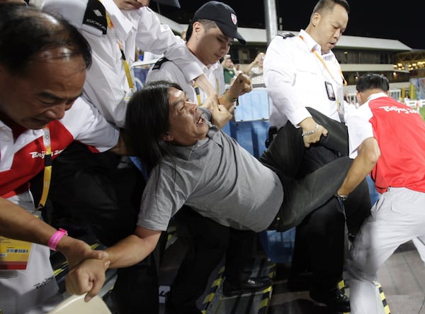 FILE - Security guards force to take away Pro-democracy protesters, Hong Kong legislator Leung Kwok-hung, also known as nickname "Long Hair", on the spectator stand during the first day of Beijing Olympics Equestrian game in Hong Kong on Aug. 9, 2008 while demanding for human rights and to stop one party ruling in China. (AP Photo/Kin Cheung, File)