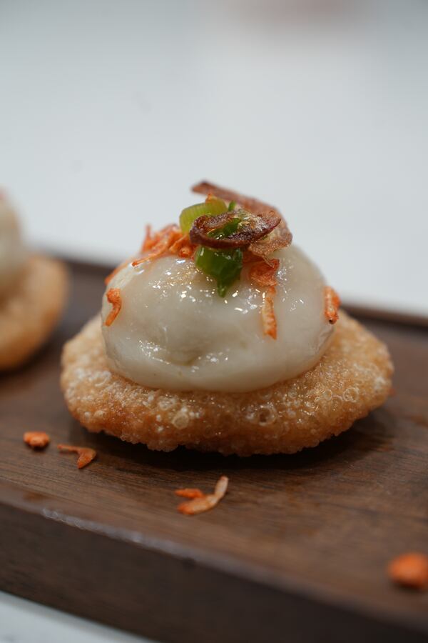 Dumpling topped with green pepper and crispy fried garnish.