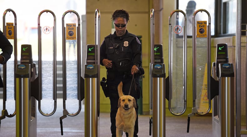 MARTA police K-9 handler Deidre Dixon guides her K-9 at the Lindbergh Center MARTA station.
