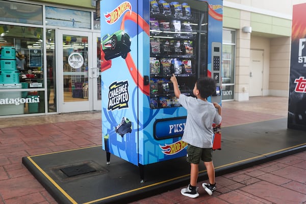 Santiago Sanchez, 4, points at a Hot Wheels car inside a vending machine at The Outlet Shoppes in Woodstock, on Friday, June 12, 2026. (Abbey Cutrer/AJC)