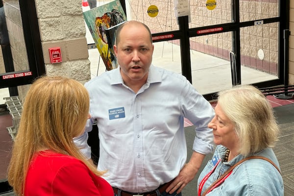 Georgia Attorney General Chris Carr, center, a GOP candidate for governor in 2026, speaks to a delegate at the Georgia Republican Convention in Dalton, Ga., Friday, June 6, 2025. (AP Photo/Jeff Amy)