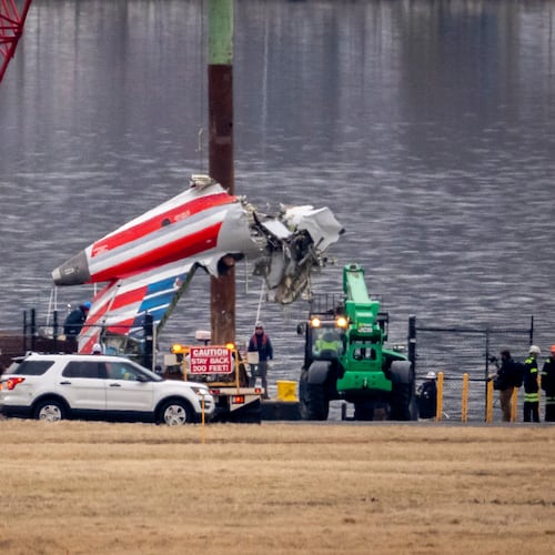 FILE - A crane offloads a piece of wreckage from a salvage vessel onto a flatbed truck, near the wreckage site in the Potomac River of a mid-air collision between an American Airlines jet and a Black Hawk helicopter, at Ronald Reagan Washington National Airport, Feb. 5, 2025, in Arlington, Va. (AP Photo/Ben Curtis, File)