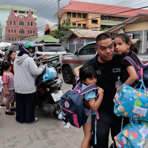 A man carries schoolgirls outside the site of a school shooting in Thailand's Nonthaburi province, Friday, Aug. 7, 2026. (AP Photo/Wason Wanichakorn)