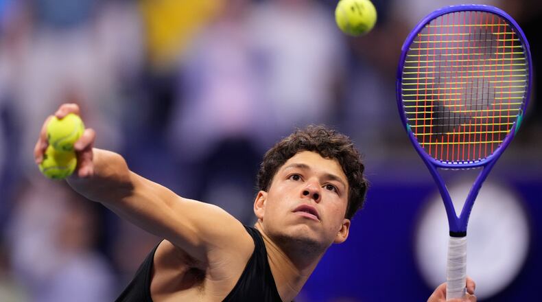 Ben Shelton, of the United States, hits balls to audience after he won his match against Frances Tiafoe, of the United States, during the men's singles semifinals of the U.S. Open tennis championships Friday, Sept. 11, 2026, in New York. (AP Photo/Yuki Iwamura)