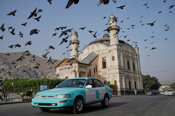 Pigeons fly outside the Shah-Do Shamshira Mosque during the Eid al-Adha prayer in Kabul, Afghanistan, Saturday, June 7, 2025. (AP Photo/Ebrahim Noroozi)