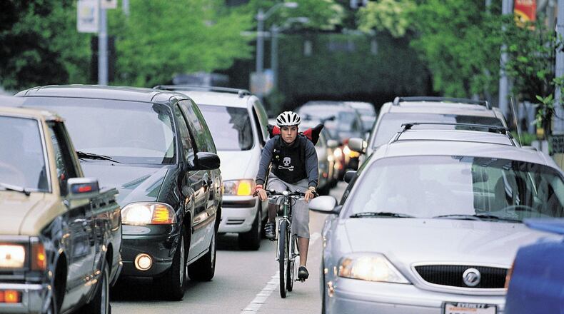 Bike commuting is soaring in popularity now that more cities are creating bike lanes and bike share programs to deal with out-of-control traffic. Both drivers and bicycle riders need to know the laws and be aware of each other to prevent accidents. Bike messenger Caitlin McElroy is shown in this 2003 file photo. (Harley Soltes/Seattle Times/MCT)