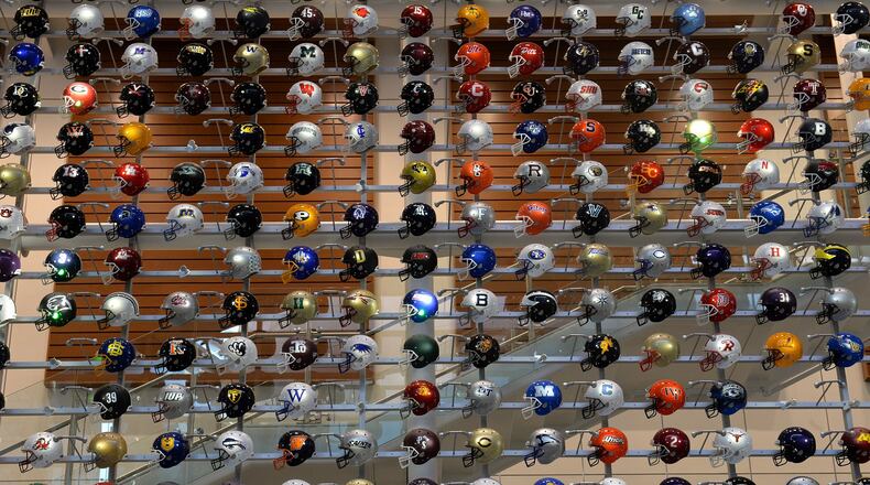 Helmets representing college football teams from across the country are on display at the College Football Hall of Fame.  (AJC file photo)