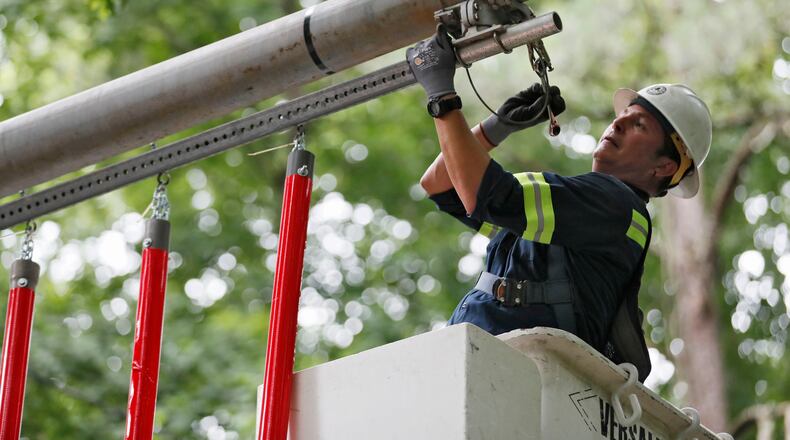 June 20, 2019 - Smyrna - Roberto Jorge, a Cobb DOT worker, works on installing the PVC pipes, a new warning system for the Concord Road covered bridge. Cobb County is rolling out yet another tool designed to warn drivers of the seven-foot clearance of the Concord Road covered bridge. The county has installed mast arms along Concord Road that will have plastic-covered PVC pipes suspended at seven feet. If a too-tall vehicle hits these pipes, they should not try to pass through the covered bridge. Bob Andres / bandres@ajc.com