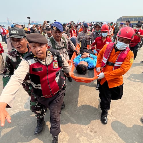 In this photo taken with a smartphone, rescuers carry a survivor from a passenger ferry overturned in bad weather in the Java Sea on a stretcher upon arrival at a port in Banjarmasin, South Kalimantan, Indonesia, Tuesday, Sept. 15, 2026. (AP Photo/Iman Satria)