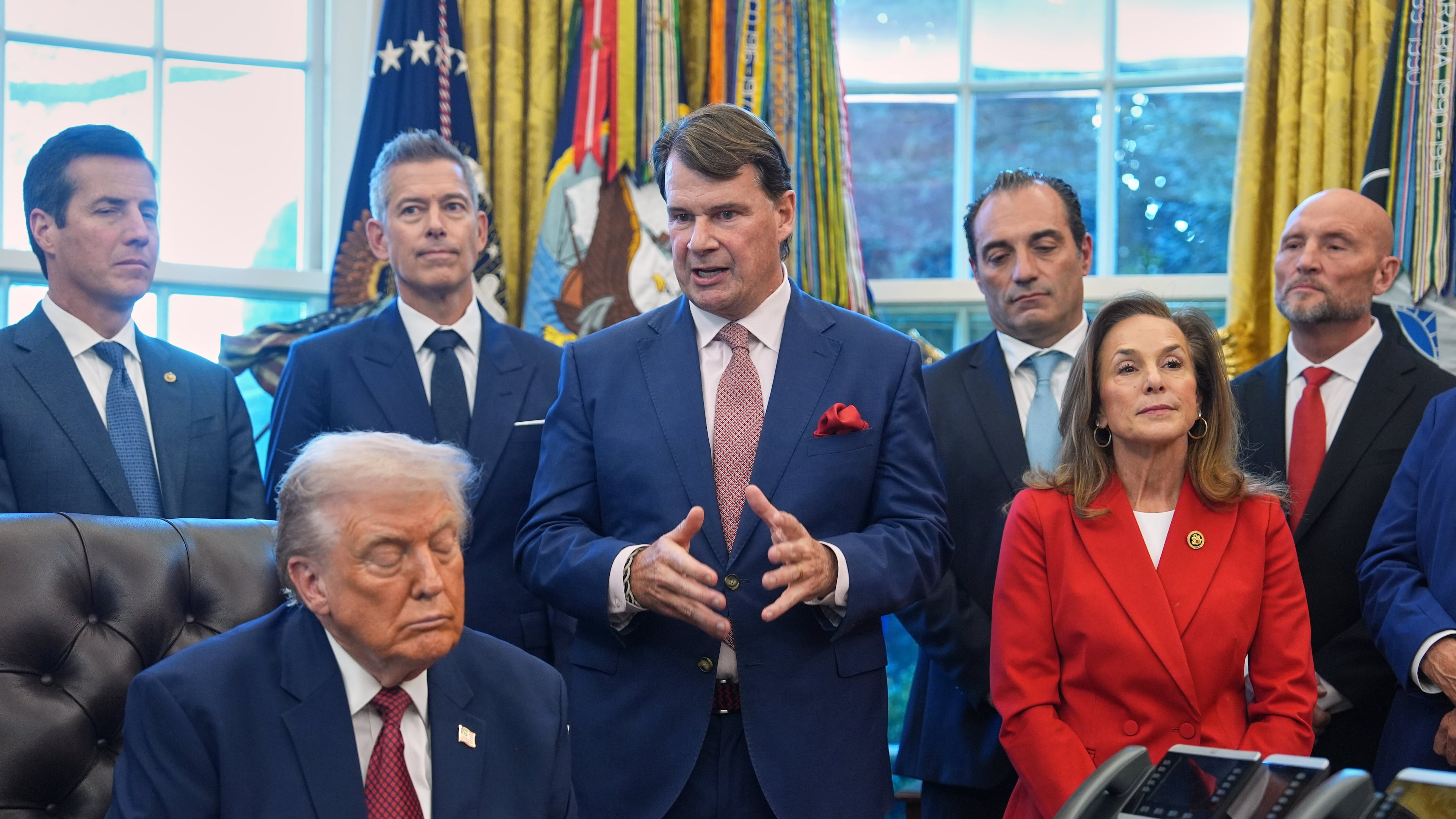 Ford President Jim Farley speaks as President Donald Trump looks on, during an event on fuel economy standards in the Oval Office of the White House, Wednesday, Dec. 3, 2025, in Washington. (AP Photo/Evan Vucci)