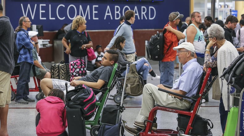 Airline travel sometimes includes hassles, like when passengers waited on lines at Hartsfield-Jackson Atlanta International Airport after a power outage caused Delta Air Lines to cancel lots of flights in August. Now, U.S. government officials are contemplating new regulations in case airlines choose to allow Wi-Fi phone calls during flights. JOHN SPINK /JSPINK@AJC.COM