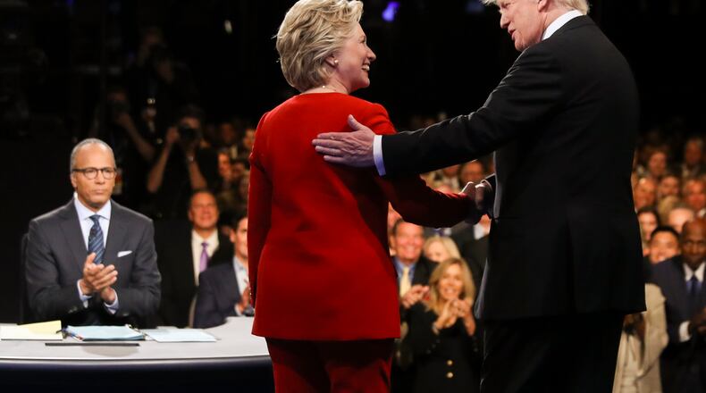 FILE - In this Sept. 26, 2016 file photo, Democratic presidential nominee Hillary Clinton and Republican presidential nominee Donald Trump shake hands during the presidential debate at Hofstra University in Hempstead, N.Y. For presidential candidates, the town hall debate is a test of stagecraft as much as substance. When Hillary Clinton and Donald Trump meet in the Sunday, Oct.9, 2016, contest, they’ll be fielding questions from undecided voters seated nearby. In an added dose of unpredictability, the format allows the candidates to move around the stage, putting them in unusually close proximity to each other. (Joe Raedle/Pool via AP, File)