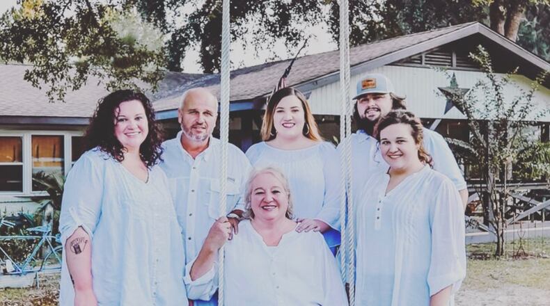 Rhonda Hudson pictured sitting in swing in January 2020 before COVID-19 left its mark on the extended family. Pictured from left to right: Mary, Tim, Elizabeth, Tyler, Olivia and Rhonda seated. (Photo courtesy of Hudson family)