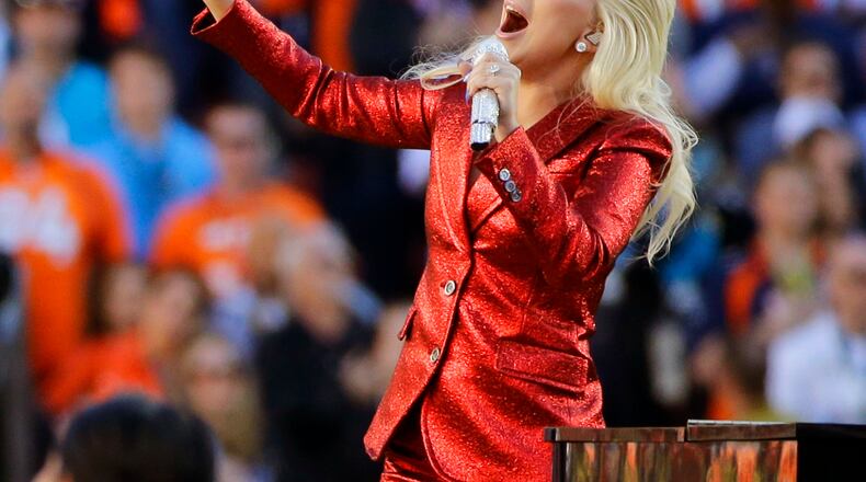 FILE - In this Feb. 7, 2016, file photo, Lady Gaga sings the national anthem before the NFL Super Bowl 50 football game in Santa Clara, Calif. Lady Gaga is reportedly planning an (unconfirmed) stunt during Super Bowl LI by performing from the roof of the stadium during the big game. Advertisers are also ramping up their marketing stunts to try to stand out from the crowd during the biggest live TV event of the year, when the Atlanta Falcons will take on the New England Patriots, in the Super Bowl. (AP Photo/Jae C. Hong, File)