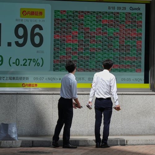 People look at an electronic stock chart board showing Japan's Nikkei index at a securities firm Tuesday, Aug. 18, 2026, in Tokyo. (AP Photo/Eugene Hoshiko)