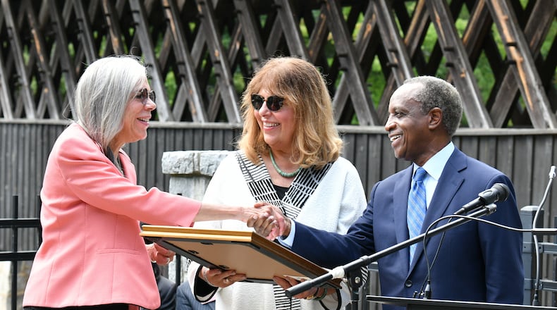 September 16, 2022 Stone Mountain - DeKalb County CEO Michael Thurmond presents a proclamation to Rebecca King Rosenberg (left) and Kathleen King, both great-great-great nieces of Washington W. King during a ceremony to "rededicate" a historic covered bridge at Stone Mountain Park. The bridge built by Washington W. King, a Black bridgebuilder that was the son of freed slaves. It once spanned the Oconee River in Athens but was moved in the 1960s to Stone Mountain Park’s Indian Island. This covered bridge is one of only four remaining structures of the many created and constructed by Washington W. King. The King family were prominent African-American businessmen for decades in multiple Georgia cities. (Hyosub Shin / Hyosub.Shin@ajc.com)