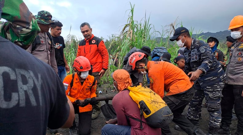In this photo released by the Indonesian National Search and Rescue Agency (BASARNAS) rescuers carry the body of a victim of the eruption of Mount Dukono, on Halmahera Island, Indonesia, Saturday, May 9, 2026. (BASARNAS via AP)