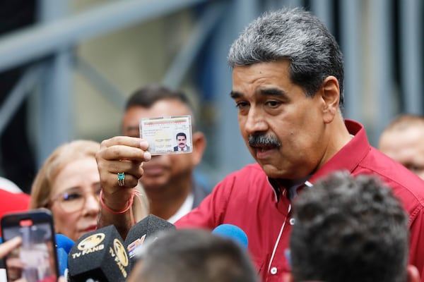 Venezuela's President Nicolas Madurai shows his ID to journalists after voting in legislative and local elections in Caracas, Venezuela, Sunday, May 25, 2025. (AP Photo/Cristian Hernandez)