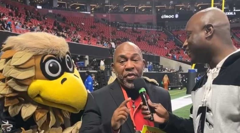 Carver-Atlanta coach Darren Myles talks to the crowd at the Falcons-Panthers game Jan. 5 after receiving word from D.J. Shockley (right) that he was the Falcons' Coach of the Year. He got two tickets to the Super Bowl to be played next month in New Orleans, his hometown.