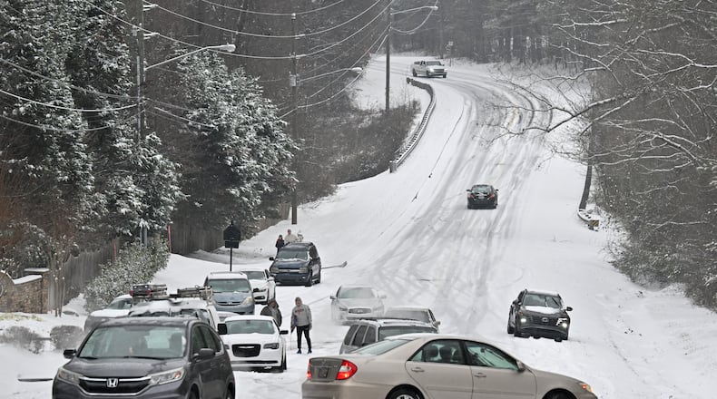 Vehicles get stuck in the snow on Old Snellville Highway on Friday, Jan. 10, 2025, in Lawrenceville. Georgia is bracing for a possibly significant winter storm expected this weekend. (Hyosub Shin/AJC)