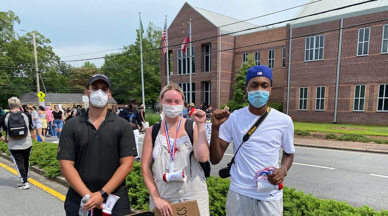 Ethan Rowe and two close friends, James Rhodes and Grace Slewitzke, led about 200 Roswell High School alumni on a protest march along Alpharetta Highway to city hall. Photo credit: Adrianne Murchison