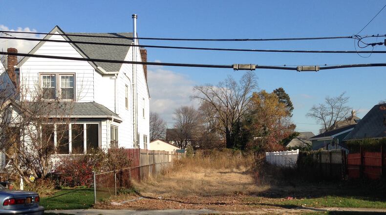 In this Nov. 25, 2015 photo, a lot stands empty in West Hempstead, N.Y., after the township had the home that once stood on it torn down. Homeowner Philip Williams says he went to Fort Lauderdale for the knee replacement in December, 2014. When he returned to the West Hempstead home in August 2015, his home was gone. (AP Photo/Frank Eltman)