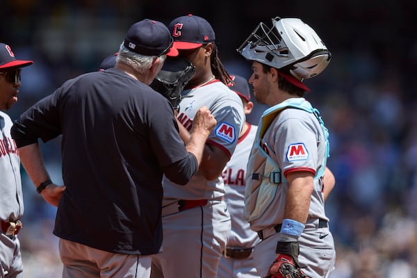 Cleveland Guardians starting pitcher Luis L. Ortiz, center, talks with pitching coach Carl Willis, second from left, and catcher Austin Hedges, right, during the second inning of a baseball game against the Seattle Mariners, Sunday, June 15, 2025, in Seattle. (AP Photo/John Froschauer)