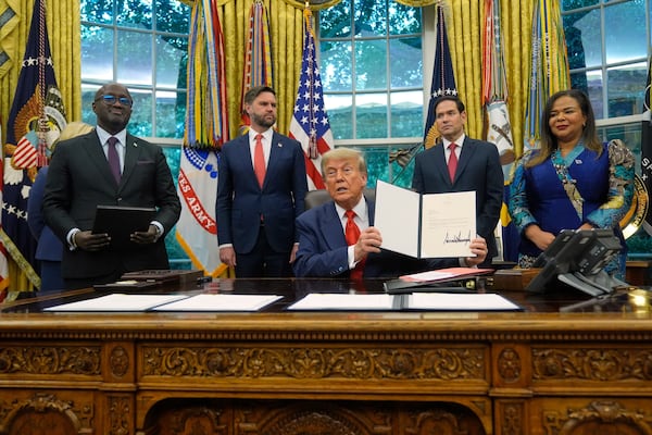 President Donald Trump holds up a signed document to present to Congo's Foreign Minister Therese Kayikwamba Wagner, right, as Rwanda's Foreign Minister Olivier Nduhungirehe, from left, Vice President JD Vance and Secretary of State Marco Rubio watch, Friday, June 27, 2025, in the Oval Office at the White House in Washington. (AP Photo/Manuel Balce Ceneta)
