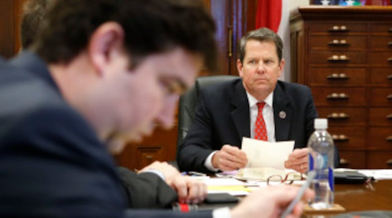 Brian Kemp in a staff meeting at his office in the Capitol. BOB ANDRES / BANDRES@AJC.COM