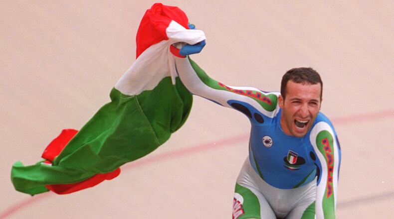 Andrea Collinelli carries the Italian flag after winning the men's individual pursuit in the cycling competitions Thursday, July 25, 1996, at the Stone Mountain Velodrome. (Rich Addicks/AJC)