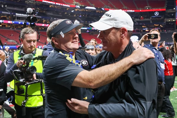 Georgia head coach Kirby Smart (left) celebrates with offensive coordinator Mike Bobo after a 28-7 victory over Alabama in the SEC championship game at Mercedes-Benz Stadium on Saturday, Dec. 6, 2025, in Atlanta. Despite calls for Bobo to be replaced after the 2024 season, Smart stuck with the longtime playcaller. (Jason Getz/AJC)