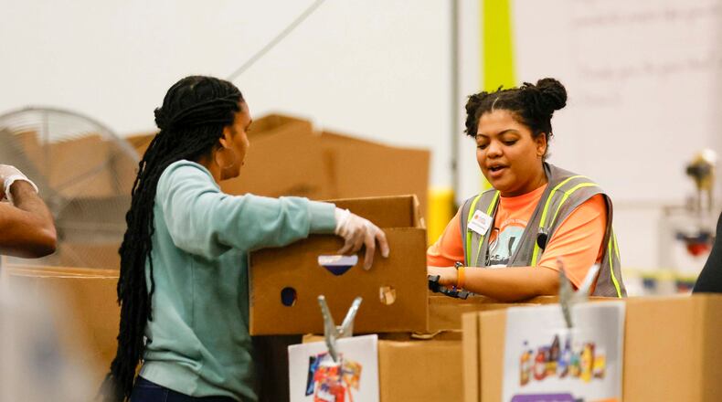 Volunteers pack food boxes at the Hunger Action Center at the Atlanta Community Food Bank Distribution Center. Requests for assistance have increased substantially since SNAP benefits have been cut off because of the government shutdown. (Miguel Martinez/AJC)