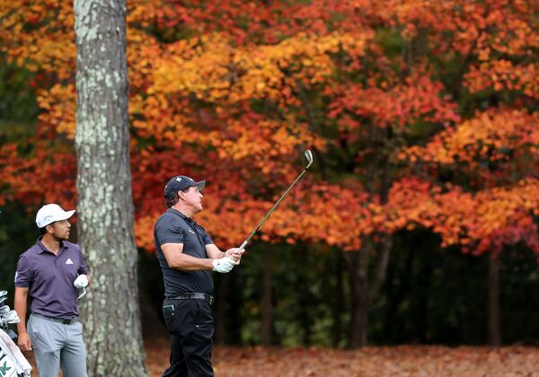 Fall leaves add some color to Augusta National Golf Club as Xander Schauffele watches Phil Mickelson’s fairway shot to the 11th green during Tuesday's practice round.
