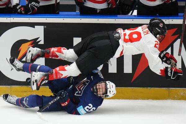 Canada's Marie-Philip Poulin falls over United States' Kendall Coyne during the gold medal match between Canada and United States at the Women's Ice Hockey Championships in Ceske Budejovice, Czech Republic, Sunday, April 20, 2025. (AP Photo/Petr David Josek)