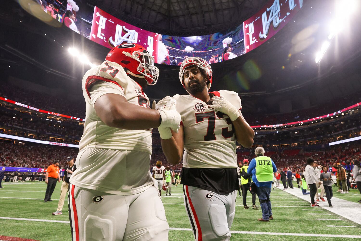 Georgia Bulldogs offensive linemen Earnest Greene III (71) and Xavier Truss (73) walk off the field following the SEC Championship football game at the Mercedes-Benz Stadium in Atlanta, on Saturday, December 2, 2023. Alabama defeated Georgia 27-24 to end the Bulldogs’ 29-game winning streak. (Jason Getz / Jason.Getz@ajc.com)