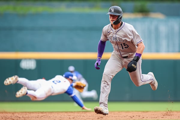 Colorado Rockies' Hunter Goodman (15) runs to third base on a single past Atlanta Braves shortstop Nick Allen, left, in the ninth inning of a baseball game, Saturday, June 14, 2025, in Atlanta. (AP Photo/Colin Hubbard)