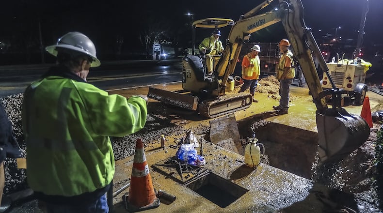 The City of Atlanta is asking voters in the March 24 election to approve a longstanding one percent sales tax to fund water and sewer projects that are mandated under a federal consent decree. Shown here are city work crews repairing a water main break on Lenox Road in January. JOHN SPINK/JSPINK@AJC.COM