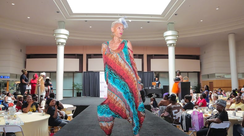 A model wearing a colorful dress struts on the catwalk at the 'Seniors on the Runway' event on May 4, 2024, at Greenbriar Mall in Atlanta.