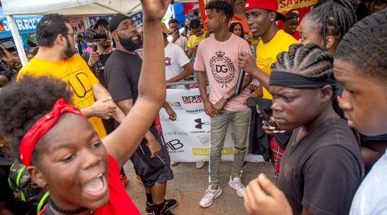 People surround 21 Savage as he walks into the fourth annual Issa Back 2 School Drive on Sunday. STEVE SCHAEFER / SPECIAL TO THE AJC