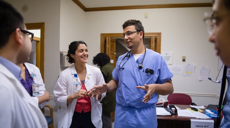 Dr. Heval Kelli (center in scrubs), a former Syrian refugee and current cardiology fellow at Emory University, speaks with medical students at the Clarkston Community Health Center in 2017. Kelli, who has previously volunteered at the clinic, is a Kurd who still has family in northeastern Syria where the withdrawal of U.S. troops has cleared the way for the Turkish military to attack U.S. allies who had helped fight ISIS. BITA HONARVAR/SPECIAL