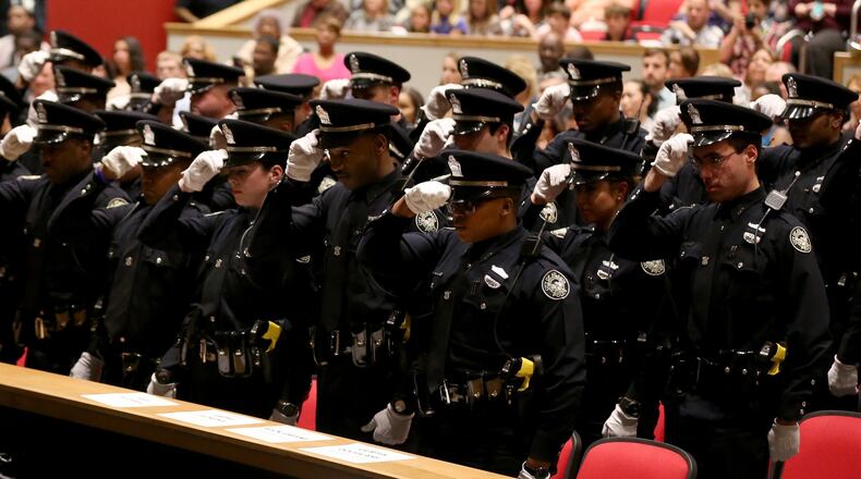 March 18, 2015 Atlanta: Atlanta Police officers prepare to remove their hats in unison during their recruit class graduation ceremony Wednesday evening March 18, 2015 at North Atlanta High School. Ben Gray / bgray@ajc.com