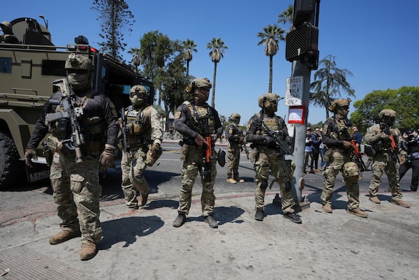 Federal agents stage at MacArthur Park Monday, July 7, 2025, in Los Angeles. (AP Photo/Damian Dovarganes)