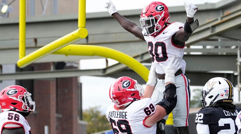 Georgia running back Daijun Edwards, second from right, celebrates a touchdown with offensive lineman Tate Ratledge (69) in the second half of an NCAA college football game against Vanderbilt, Saturday, Oct. 14, 2023, in Nashville, Tenn. Georgia won 37-20. (AP Photo/George Walker IV)